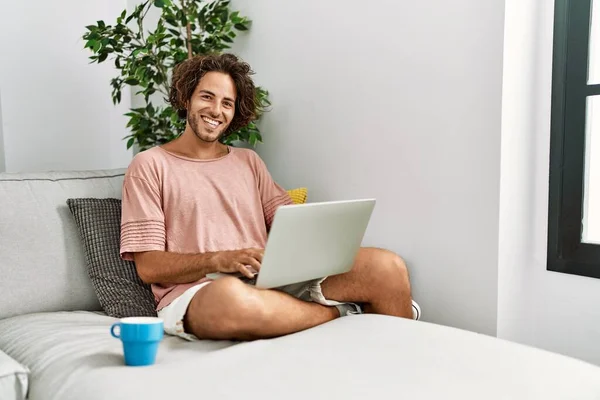 Joven Hombre Hispano Sonriendo Feliz Usando Portátil Sentado Sofá Casa —  Fotos de Stock