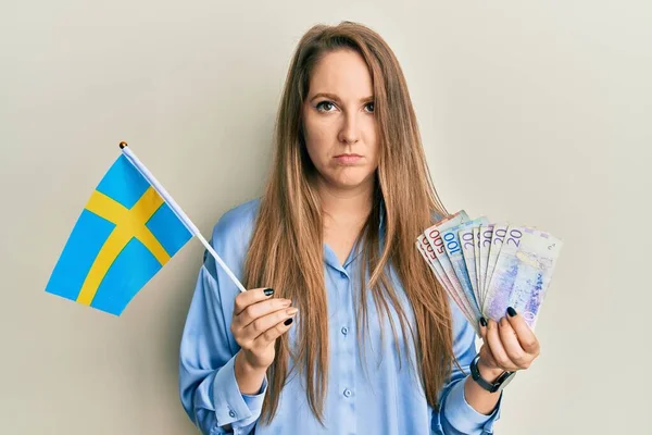 Elinde Sveç Bayrağı Krone Banknotları Tutan Genç Sarışın Kadın Şüpheci — Stok fotoğraf