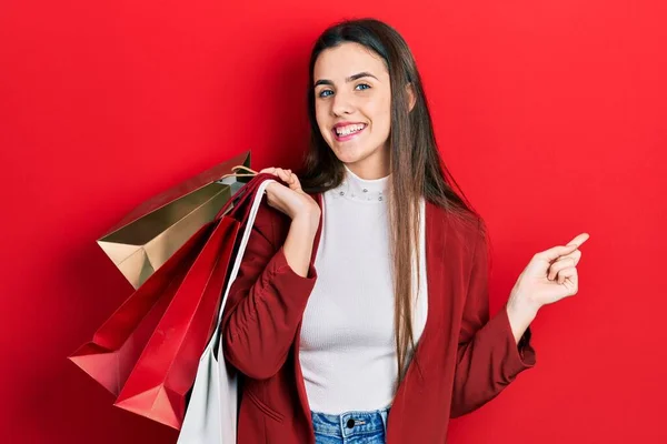 Mladá Brunetka Teenager Drží Nákupní Tašky Úsměvem Šťastný Ukazující Rukou — Stock fotografie