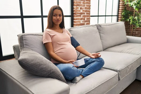 Mujer Embarazada Joven Usando Monitor Presión Arterial Sentado Sofá Soplando —  Fotos de Stock