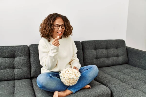 Volwassen Latino Vrouw Eten Popcorn Kijken Zitten Bank Thuis — Stockfoto