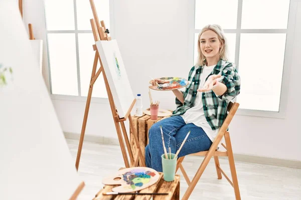 若いアーティスト女性絵画上のキャンバスでアートスタジオ笑顔明るい提供ヤシの手を支援し 受け入れを与える — ストック写真