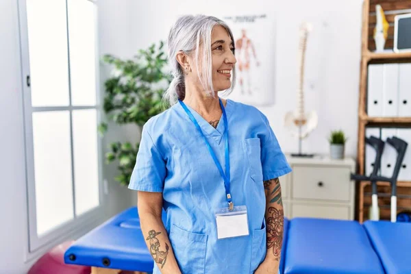 Medelålders Gråhårig Kvinna Bär Sjukgymnast Uniform Läkarkliniken Tittar Bort Till — Stockfoto