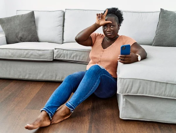Ung Afrikansk Kvinna Med Smartphone Sitter Golvet Hemma Gör Narr — Stockfoto