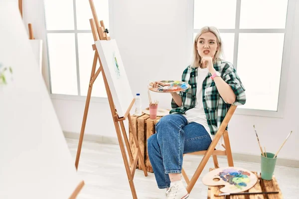 在艺术工作室的画布上 年轻的女画家正在思考着一个问题 她双手托着下巴 忧心忡忡 — 图库照片