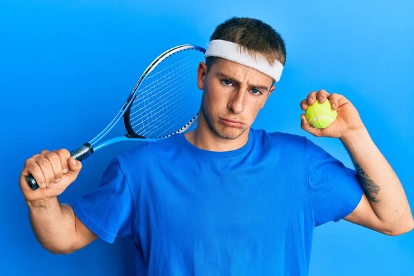 若い白人男性がラケットを持ってテニスをしているとボールが落ち込んでおり 苦痛のために心配し 怒って恐れて泣いています 悲しい表情 — ストック写真