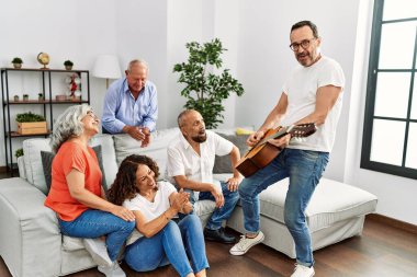 Bir grup orta yaşlı arkadaş evdeki kanepede oturup klasik gitar çalıyorlar..