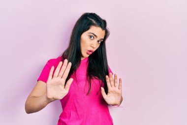 Sıradan pembe tişörtler giyen genç İspanyol bir kız. Avuçlarını hareket ettiriyor. Korkmuş ve iğrenç bir ifadeyle reddediyor. Dur ve yasakla. 