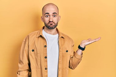 Genç kel adam avuçlarını açmış, elinde komik yüzüyle şişen bir şey tutuyor. Ağzı havayla şişer, havayı yakalar.. 