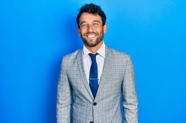 Sakallı, takım elbiseli, kravatlı, mutlu ve havalı bir gülümsemesi olan yakışıklı bir adam. şanslı kişi. 