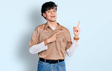 90 'ların modası geçmiş yakışıklı genç adam gülümsüyor ve kameraya bakıyor iki eliyle ve parmaklarıyla kenarı işaret ediyor.. 