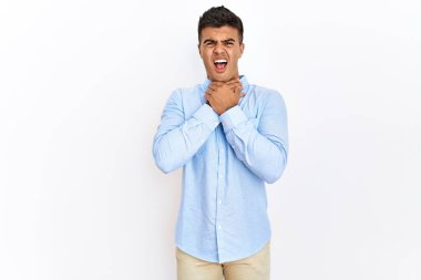 İş gömleği giyen genç İspanyol bir adam izole edilmiş arka planda durup boğularak ölmek için bağırıyor çünkü acı verici bir boğulma. Sağlık problemi. Boğulma ve intihar konsepti. 