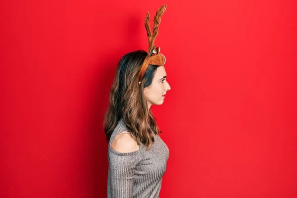 Young Hispanic Girl Wearing Deer Christmas Hat Looking Side Relax — стоковое фото