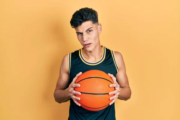 Jeune Homme Hispanique Tenant Ballon Basket Sceptique Nerveux Fronçant Les — Photo