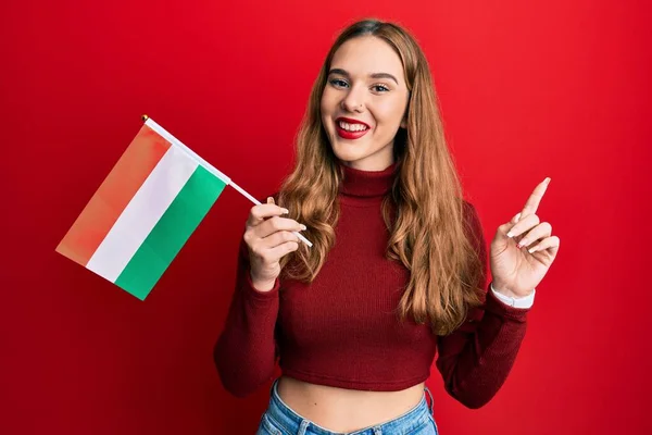 Jovem Loira Segurando Bandeira Húngara Sorrindo Feliz Apontando Com Mão — Fotografia de Stock
