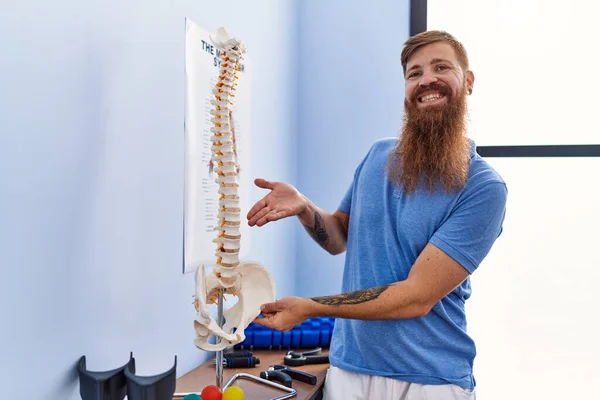 Joven Pelirrojo Vistiendo Uniforme Fisioterapeuta Apuntando Modelo Anatómico Columna Vertebral — Foto de Stock