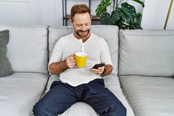 Homem Hispânico Meia Idade Usando Smartphone Bebendo Café Casa — Fotografia de Stock