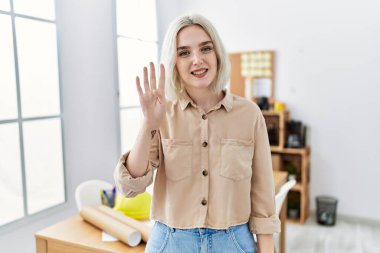 İnşaat ofisindeki güzel beyaz kadın dört numarayı gösterip işaret ederken kendinden emin ve mutlu bir şekilde gülümsüyor.. 