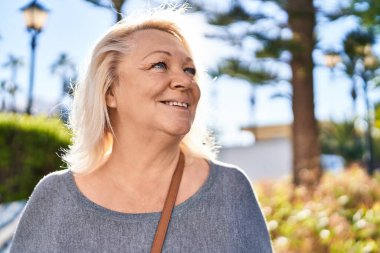 Parkta kendine güvenen orta yaşlı sarışın bir kadın.