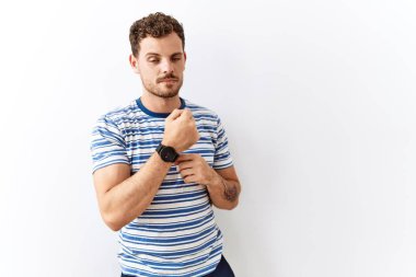 Yakışıklı genç adam tecrit edilmiş arka planda dikiliyor. Aceleyle zamanı, sabırsızlığı ve rahatlamış bir ifadeyle kameraya bakıyor. 