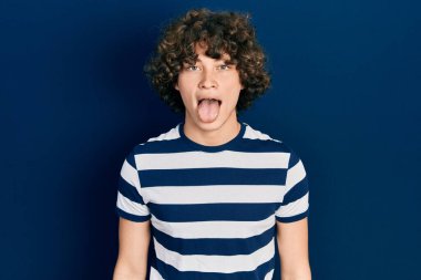 Sıradan çizgili tişört giyen yakışıklı genç adam komik bir ifadeyle dilini dışarı çıkarıyor. duygu kavramı. 