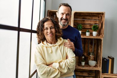 Orta yaşlı İspanyol çift gülümsüyor. Mutlu mesut evdeki pencereye yaslanıyorlar..