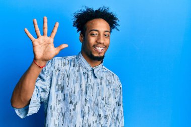 Sakallı, genç, Afro-Amerikan bir adam. Beş numaralı parmaklarıyla kendini beğenmiş ve mutlu gülümserken kendini belli ediyor.. 