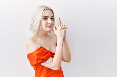 Kafkasyalı genç bir kadın, izole edilmiş arka planda duruyor. Elinde sembolik bir silahla el hareketleriyle cinayet silahlarıyla, kızgın bir yüzle oyun oynuyor. 