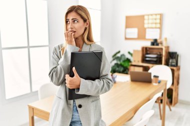 Ofisteki sarışın iş kadını gergin ve gergin görünüyor. Ağzı tırnak yiyen ellerle. anksiyete. 