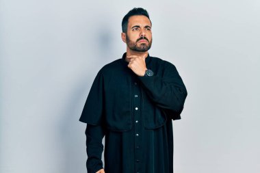 Sakallı yakışıklı, Katolik rahip cübbesi giyen, boynu ağrıyan, boğazı ağrıyan, grip, mantar ve enfeksiyon kapmış bir adam. 