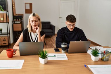 Ofiste çalışan ciddi ifadeli iki iş adamı..