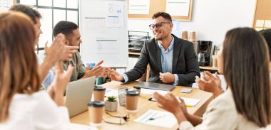 Ofisteki ortağına gülümseyen ve alkışlayan bir grup işçi..