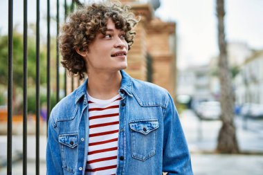 Genç İspanyol adam şehre gülümsüyor.