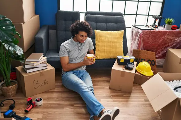 Young Hispanic Man Drinking Coffee Sitting Floor New Home — Stock Photo, Image