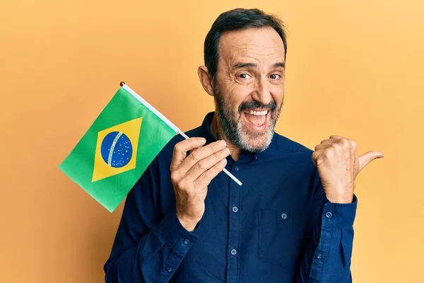 Středověký Hispánec Drží Brazilskou Vlajku Ukazující Palcem Nahoru Stranu Usmívá — Stock fotografie