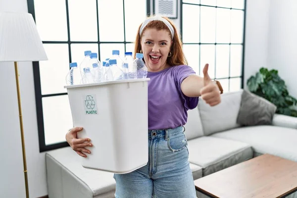 Ung Rödhårig Kvinna Som Håller Återvinning Papperskorg Med Plastflaskor Godkännande — Stockfoto