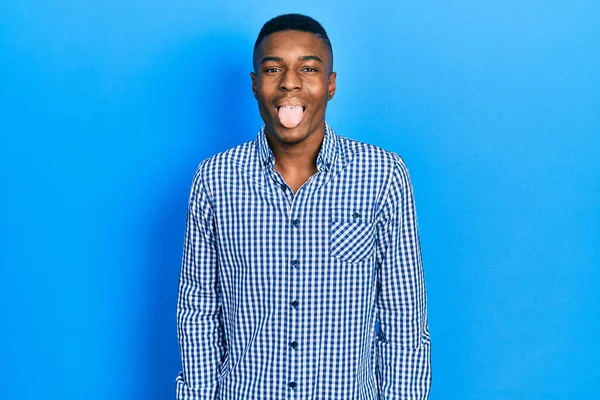 若いアフリカ系アメリカ人の男性が面白い表情で幸せ舌を突き出してカジュアルな服を着ています 感情の概念 — ストック写真
