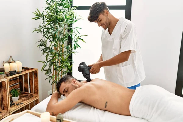 Two Hispanic Men Physiotherapist Patient Massaging Back Using Percussion Gun — Stock Photo, Image