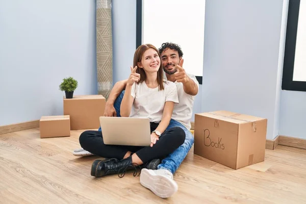 Casal Jovem Usando Laptop Nova Casa Apontando Dedos Para Câmera — Fotografia de Stock