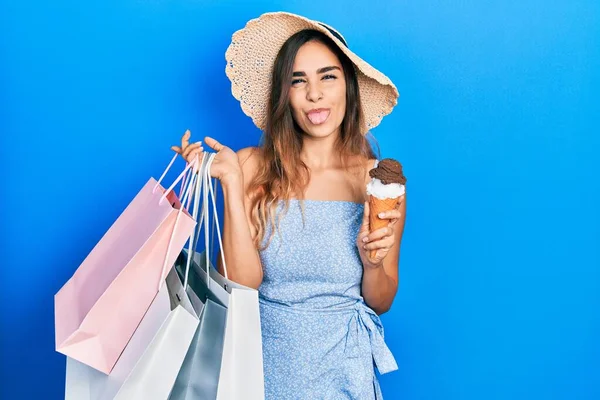 若いですヒスパニック女の子保持ショッピングバッグとアイスクリームステッキング舌アウト幸せとともに面白い式 — ストック写真