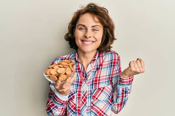 Genç Esmer Kadın Elinde Tuzlu Bisküvilerle Bağırarak Zaferi Başarıyı Kutluyor — Stok fotoğraf