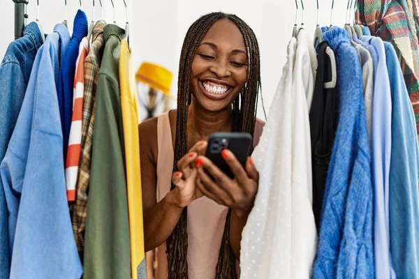 Молодая Африканская Женщина Покупатель Улыбается Счастливой Появляясь Через Одежду Используя — стоковое фото