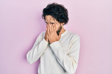 Yakışıklı, beyaz süveter giyen, yorgunluk ve baş ağrısı için gözlerini ovuşturan, uykulu ve yorgun bir adam. görme sorunu 