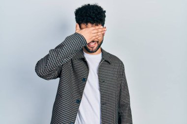 Sakallı, gözlüklü, gülümseyen ve gülümseyen genç bir Arap şaşırtmak için gözlerini kapatıyor. kör kavram. 