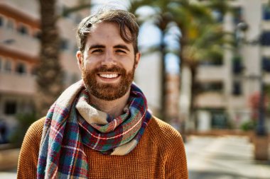 Güneşli bir günde, açık havada sakallı, beyaz bir genç.