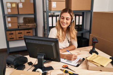 Genç sarışın kadın ecommerce iş çağrı merkezi ajanı ofiste çalışıyor.