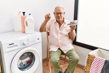 Son sınıf öğrencisi elinde çevre dostu kağıtlarla çamaşır yıkıyor öfkeyle bağırıyor, öfkeyle bağırıyor ve el kaldırıyor. 