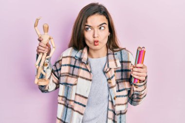 Küçük ahşap manikür ve kalemler tutan genç beyaz kız balık suratlı ve şaşı gözlü, çılgın ve komik.. 