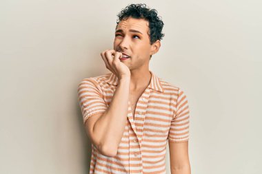 Makyaj yapan yakışıklı bir adam. Günlük tişört giyiyor. Stresli ve gergin görünüyor. anksiyete. 