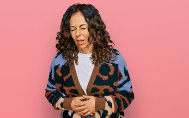 Orta yaşlı İspanyol kadın midesi üstünde günlük kıyafetler giyiyor çünkü hazımsızlık, acı verici bir hastalık kendini iyi hissetmiyor. Ağrı kavramı. 